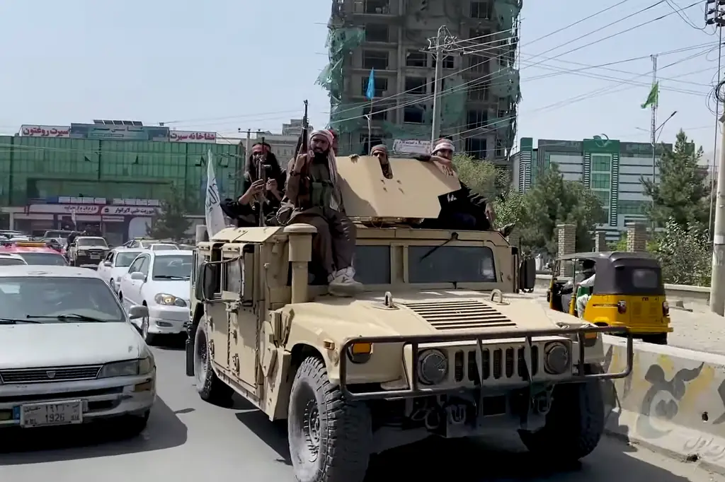 A Taliban Humvee in Kabul, manned by four warriors atop it.