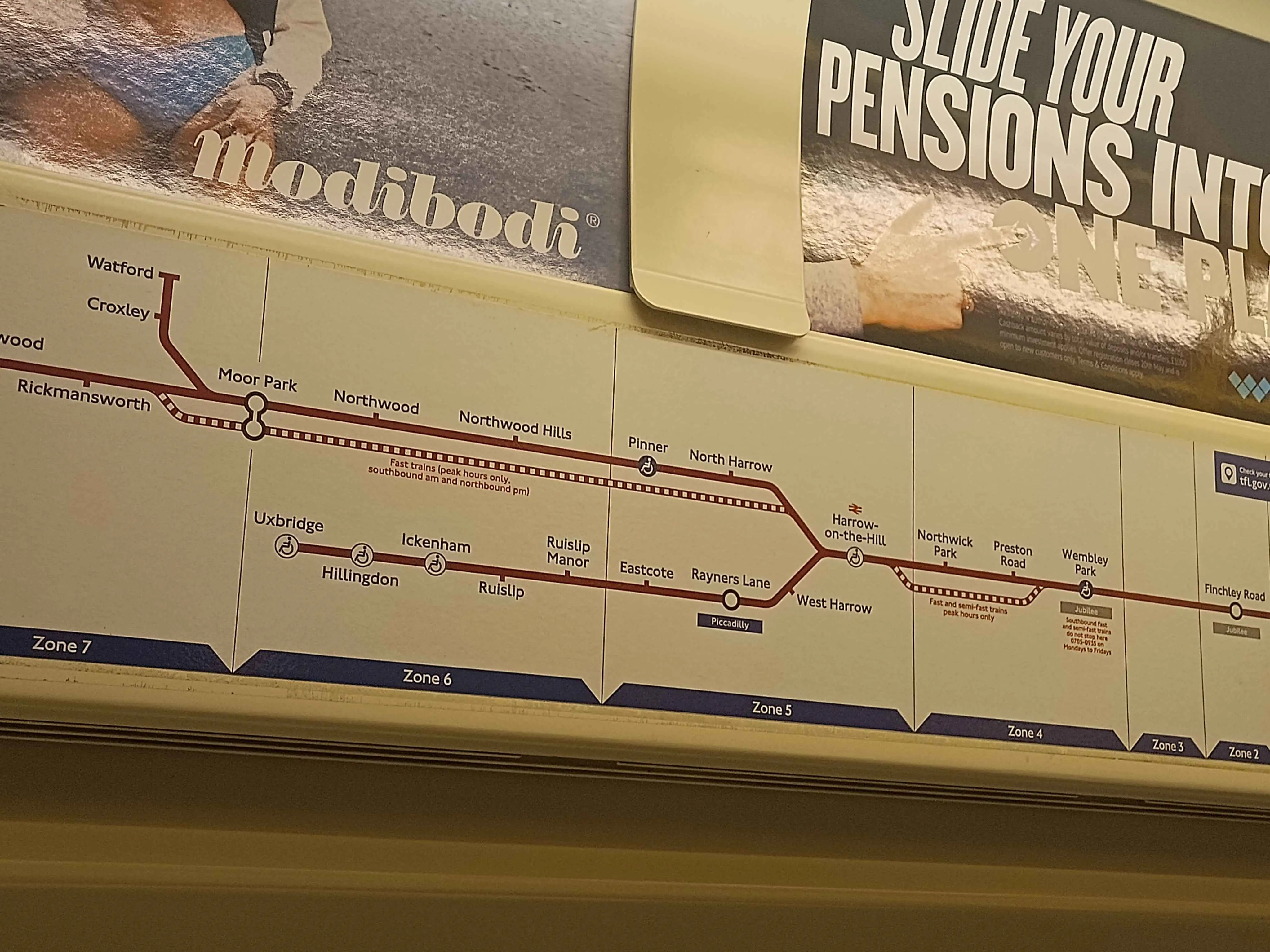 A Metropolitan line map placed under advertisements, showing the Fast and Semi-Fast routes skipping over several stops on the line.